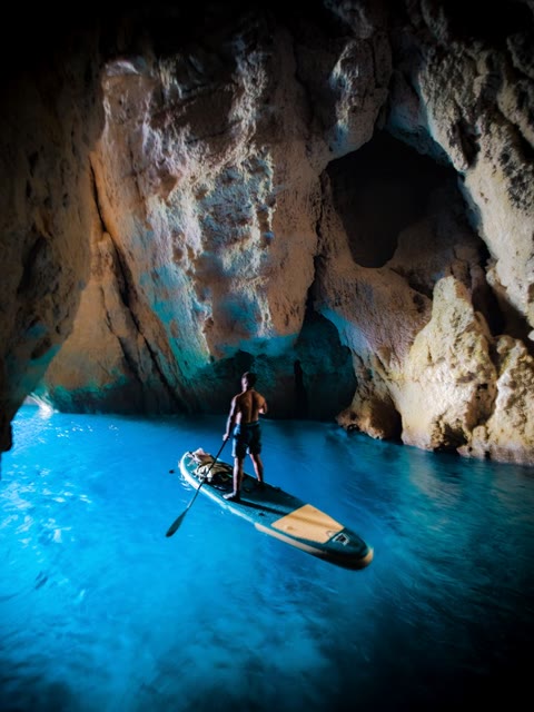 Paddle board in a blue sea cave