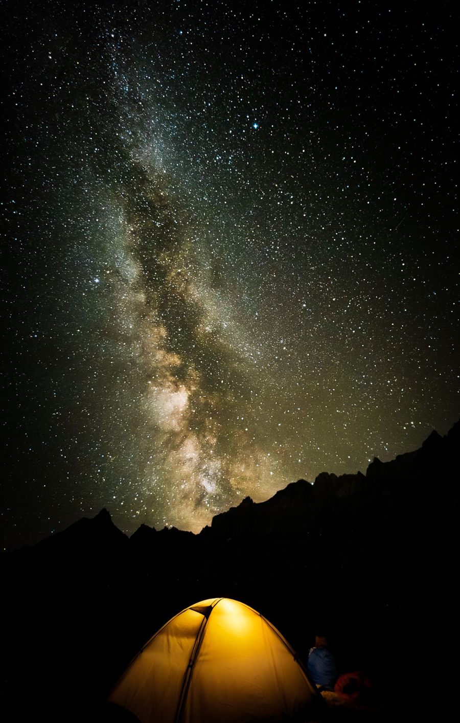 Lit tent under the Milky Way